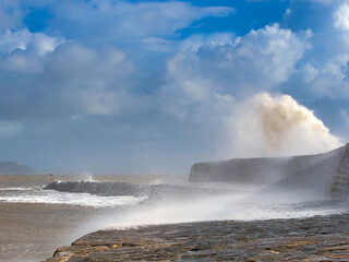 Stormy waves crashing over the Cobb seawall at Lyme Regis at the tail end of Storm Ciarán