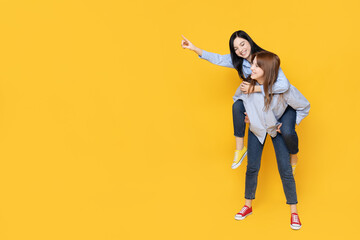 Young girls pose on a yellow background