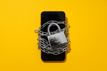 The smartphone is encased in a chain with a lock