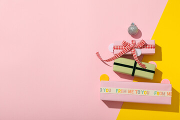 Gift boxes on pink and yellow background, space for text