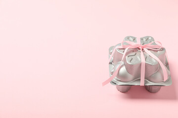 Silver box with ribbon on pink background, space for text