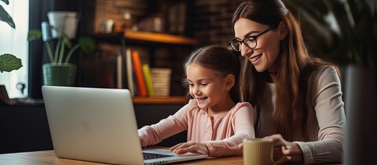 Young woman and daughter using laptop to search for homework information at home copy space image