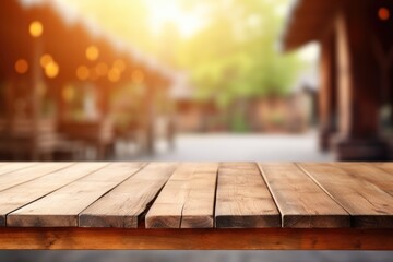 empty wooden table top for product display montages with blurred farm barns and buildings background - obrazy, fototapety, plakaty