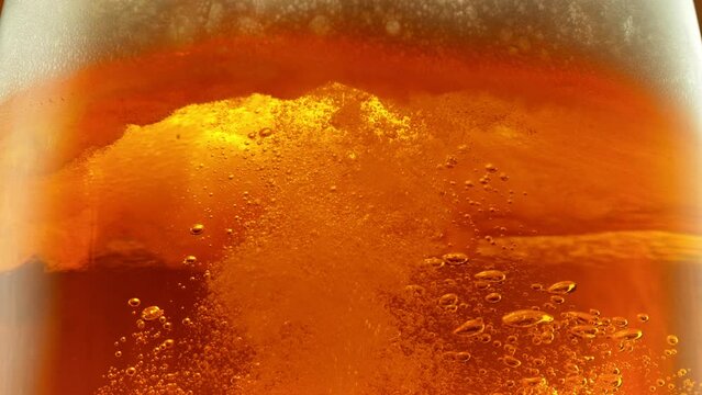 Super Slow Motion Detail Shot of Bubbling and Swirling Fresh Beer in Glass at 1000fps.
