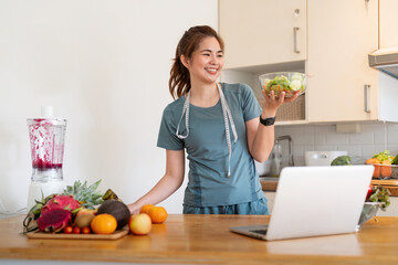 Young woman eat healthy food sitting in the kitchen
