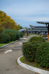 Solar panels on the parking lot. Road. Arrows. Ornamental plants. Provence, France.