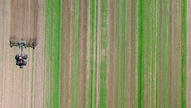 Machines till the fields for the coming harvest year. Top down drone shot.