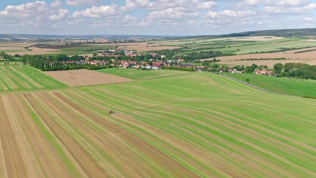 Machines till the fields for the coming harvest year. Wide angle drone shot.