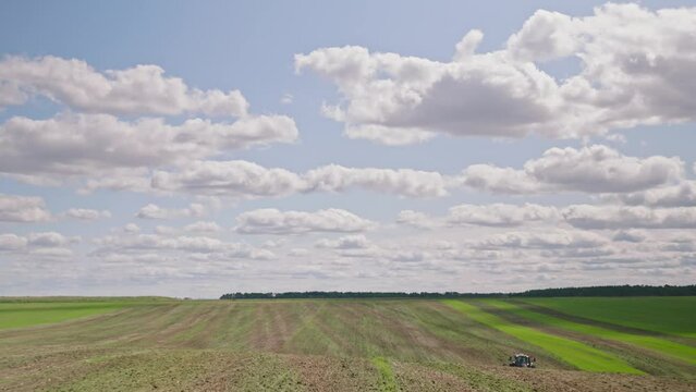 Machines till the fields for the coming harvest year. Wide angle drone shot.