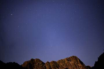 Night landscape with starry sky seen from rocky mountains