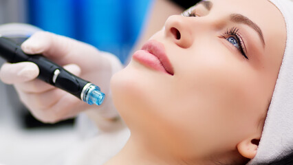 Professional dermatologist in medical gloves doing hydro peeling procedure for beautiful woman...
