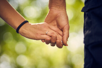 Close-up of young people holding each other tenderly while walking in the park