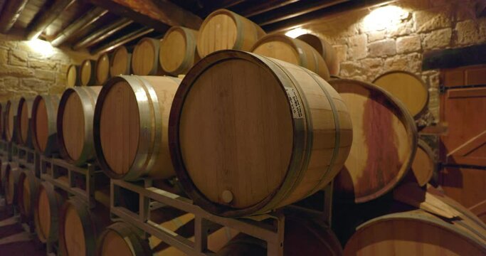 Large barrels in the cellar of the winery where the wine ages. Wine factory production and the work of a winemaker. High quality 4k footage