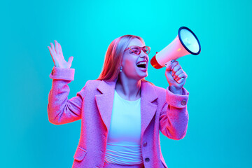 Portrait of young woman loudly screaming to loudspeaker about starting sales season against gradient background illuminated mixed colors neon light.