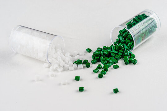 white and green plastic dye in granules in test tubes isolated on a white background