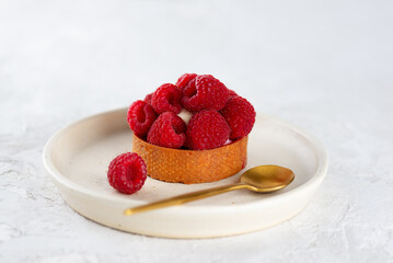 Tartlet with raspberries and cream in a plate, fresh dessert for breakfast.