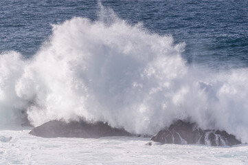 Spectacularly big waves from the pacific ocean smash into the californian coast along US highway 1.