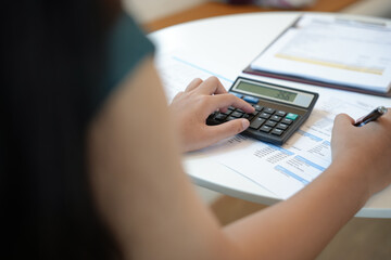 Businesswoman Accountant analyzing investment charts Invoice and pressing calculator buttons over documents. Accounting Bookkeeper Clerk Bank Advisor And Auditor Concept.