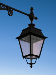 Fototapeta na wymiar Street lamp with neutral blue background. Italy