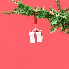 Closeup Gift box Christmas decoration hanging on Christmas tree on Red background. 3D Rendering Christmas concept idea.