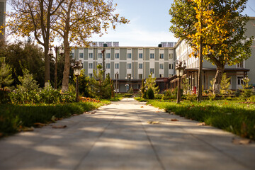 a building nearby with a grasses on both side walking path