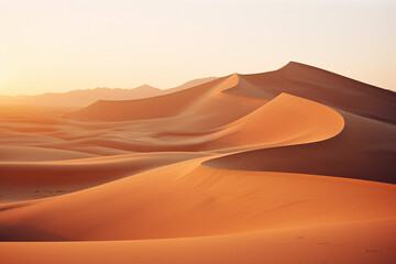 Golden hour photograph of sand dunes in the desert, capturing the shifting shadows and warm hues of a desert sunset.