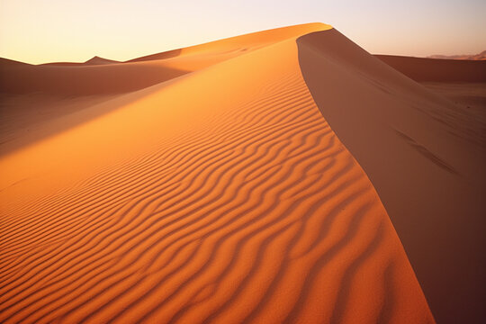 Golden hour photograph of sand dunes in the desert, capturing the shifting shadows and warm hues of a desert sunset.