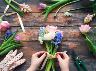 Florist at work. Woman making bouquet of spring flowers