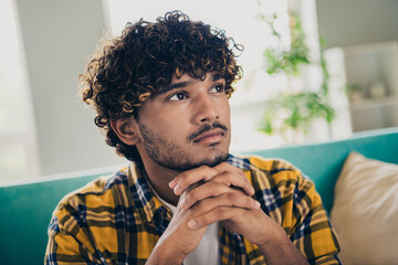Photo of creative concentrated nice man sit couch hands touch chin brainstorming contemplate apartment indoors