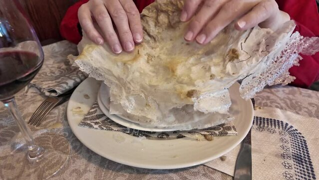 SLOW MOTION: A woman enjoying the flavors of a Borlengo, classic dish featuring meat and cheese,hailing from Italy's Emilia-Romagna. It's especially loved in Modena and Bologna for its delicious taste