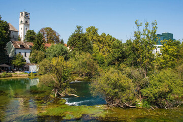 The River Una as it passes through central Bihac in Una-Sana Canton, Federation of Bosnia and Herzegovina. The Captain's Tower and Saint Anthony of Padua Church on the left