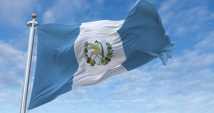 Guatemala flag with flagpole waving in wind, rolling clouds background looping, 4K video (Perfect Loop)