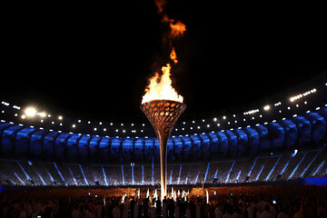 Olympic flame, a powerful symbol of peace and unity, burning brightly atop a unique torch design during a open ceremonial event