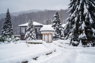 Amazing winter landscape with softly falling snow and thick snowdrifts in the courtyard of the Sokolski Monastery near Gabrovo, Bulgaria