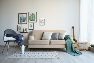Stylish living room interior with comfortable sofa, chair and plaids