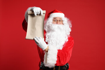 Merry Christmas. Santa Claus showing blank paper sheet on red background