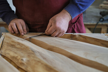 A woodworker's precise measurement, detail emphasized. Resonates with the DIY movement's push for skill learning.