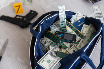 Black duffel bag full of dollar notes in criminal investigation unit, conceptual image - obrazy, fototapety, plakaty