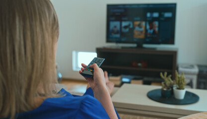 Woman watches content on her Smart TV at home.