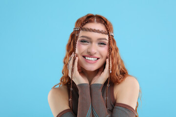 Beautiful young hippie woman on light blue background