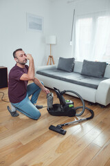 Man cleaning apartment with vacuum cleaner.