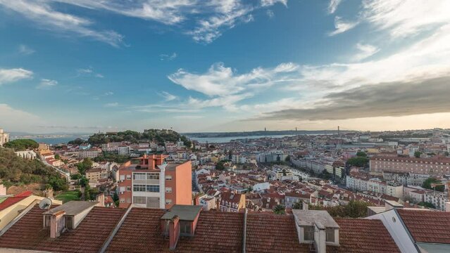 Panorama showing Lisbon famous aerial view from Miradouro da Senhora do Monte highest viewpoint of Alfama and Mauraria old city district timelapse, 25th of April Bridge before sunset. Lisbon, Portugal