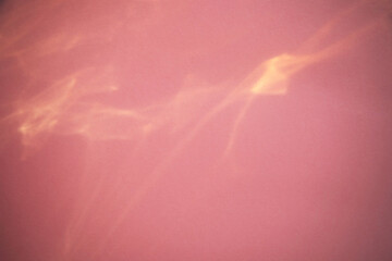 Abstract blurred pink background, backdrop with sun reflection. Caustic effect of sunlight. Empty...