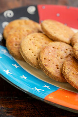 Homemade cookies on a colorful plate and wooden table with shallow depth of field.