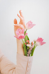 hands flowers on background. Close-up of beautiful intricate female hands with pink flowers on a white background. Hand care concept, anti-wrinkle, anti-aging cream. High quality photo