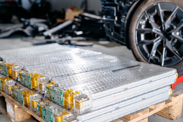 Pack of battery cells module on platform. Modern battery for an electric car separate from the vehicle at workshop.