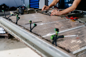 Unrecognizable technician engages with an EV Car Battery Cell Module troubleshooting a modern...