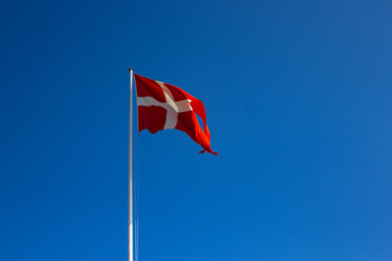 Denmark flag on the blue sky. Close up waving flag of Denmark.