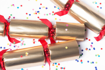 Isolated Christmas golden color crackers and confetti, holiday festive crackers on white...