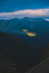 The ray of light hitting the side of a rocky mountain. Cloudy weather after a summer storm in the Carpathian Mountains of Romania © badescu